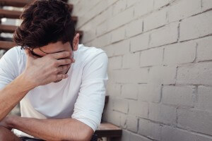 young man hiding his face