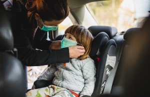 woman buckling child into carseat