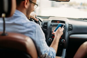 young man texting while driving