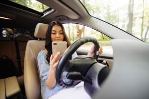 teen girl using phone while driving